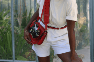 Une tenue portée par un mannequin, harmonisée avec un sac en cuir rouge