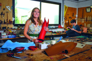 Une femme avec un joli sourire dans un atelier de fabrication de produits en cuir.