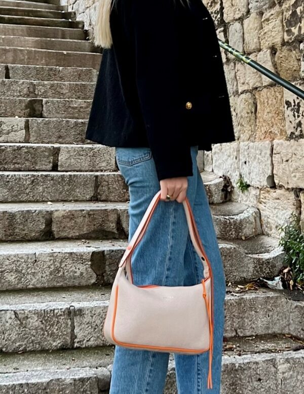 femme tenant un sac muse en cuir beige et orange